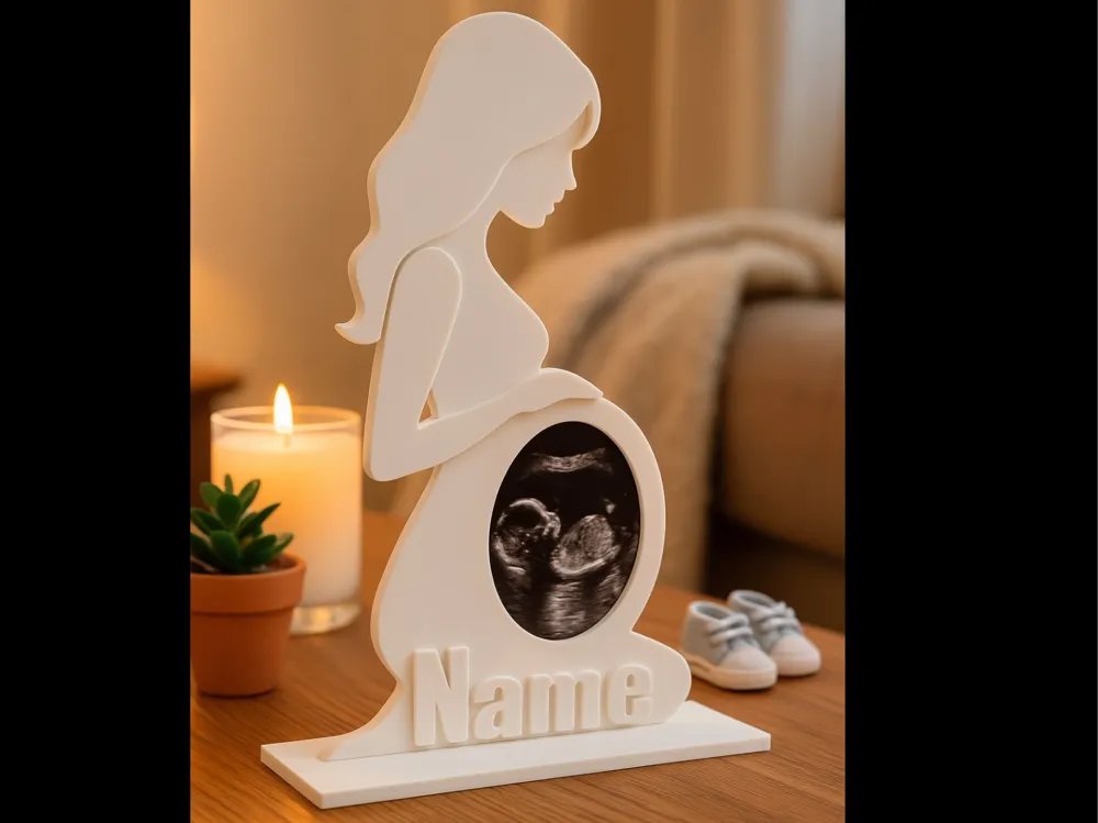 Ivory 3D-printed silhouette keepsake of an expectant mother holding a framed sonogram photo with a personalized name base